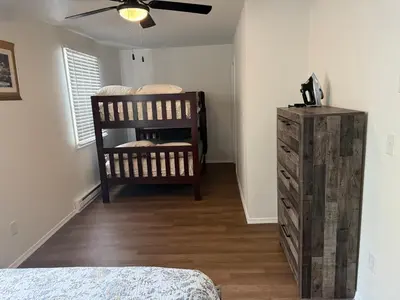 a bedroom with a bed and a dresser and a fan at POCONOS everything close to Luxury vacational home in the heart of poconos with 3 outdoor pools for the public of the Tobyhanna community in Tobyhanna