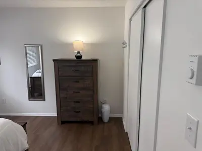 a bedroom with a dresser with a lamp and a mirror at POCONOS everything close to Luxury vacational home in the heart of poconos with 3 outdoor pools for the public of the Tobyhanna community in Tobyhanna