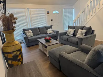 a living room with two couches and a table at POCONOS everything close to Luxury vacational home in the heart of poconos with 3 outdoor pools for the public of the Tobyhanna community in Tobyhanna