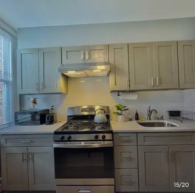 a kitchen with white cabinets and a stove top oven at Spacious 3-bedroom Apartment Stunning Views NYC in Union City