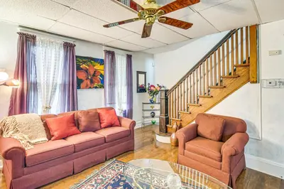 a living room with a couch and a staircase at Bethlehem Home with Patio and Amazing Sunset Views! in Bethlehem
