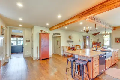 a large kitchen with wooden floors and a large island at 3 Mi to Dtwn Charming Farmhouse in Mount Joy! in Mount Joy