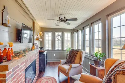 a living room with a fireplace and a ceiling fan at 3 Mi to Dtwn Charming Farmhouse in Mount Joy! in Mount Joy