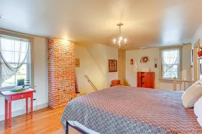 a bedroom with a bed and a brick wall at 3 Mi to Dtwn Charming Farmhouse in Mount Joy! in Mount Joy