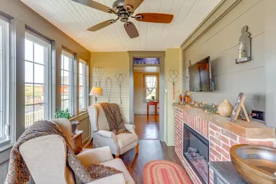 a living room with a fireplace and a ceiling fan at 3 Mi to Dtwn Charming Farmhouse in Mount Joy! in Mount Joy
