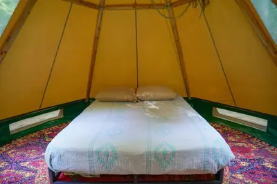 a bed in a yellow tent in a room at Lenape at Moon Valley Campground in Vernon Township
