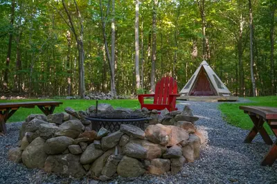 a fire pit and a tent in a park at Lenape at Moon Valley Campground in Vernon Township