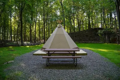 a picnic table with a teepee in a park at Lenape at Moon Valley Campground in Vernon Township