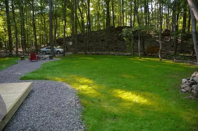 a grassy yard with a car parked in the background at Lenape at Moon Valley Campground in Vernon Township
