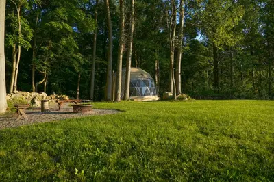 a greenhouse in a park with green grass and trees at The Lookout at Moon Valley Campground in Vernon Township