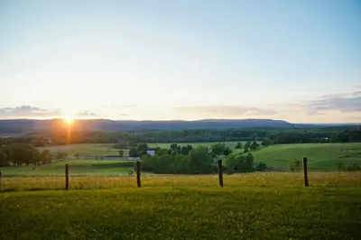 a fence in a field with the sunset in the background at The Lookout at Moon Valley Campground in Vernon Township