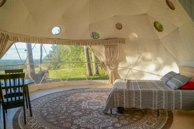 a bedroom with a bed in a room with a large window at The Lookout at Moon Valley Campground in Vernon Township