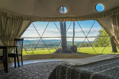 a bedroom with a bed and a large window at The Lookout at Moon Valley Campground in Vernon Township