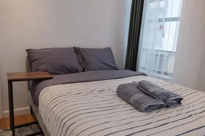 a bed with two towels on it with a window at 3 BD next to Central Park in New York