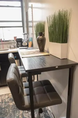a black desk with a chair and a vase with grass at 3 BD next to Central Park in New York