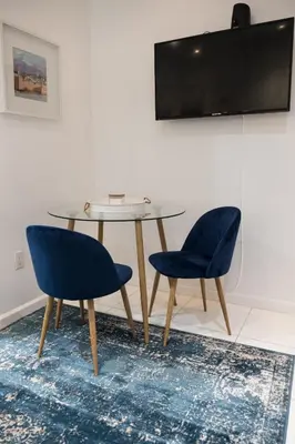 a table with two chairs and a tv on a wall at 3 BD next to Central Park in New York
