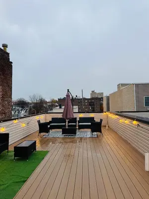 a rooftop deck with furniture and lights on a building at NYC Gateway, 30minutes from Manhattan in Jersey City
