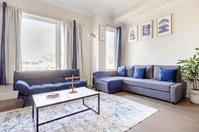 a living room with blue couches and a table at NYC Gateway, 30minutes from Manhattan in Jersey City