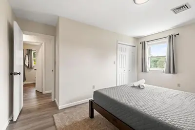 a white bedroom with a bed and a window at Joyful 5 Bedroom Home in Harrisburg