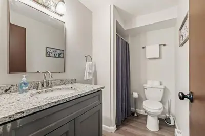 a bathroom with a sink and a toilet and a mirror at Joyful 5 Bedroom Home in Harrisburg