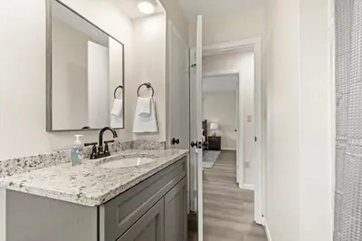 a white bathroom with a sink and a mirror at Joyful 5 Bedroom Home in Harrisburg