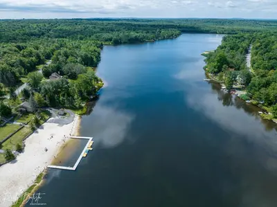 an aerial view of a river with a beach at COZY COTTAGE Spacious 4Bdrm 2Bth, Hot Tub, Game Movie Room, Close to camelback skiing, Sauna Firepit, Arcades, Backyard Playground, 2 Min Walk To Pool, Lake, Beach, Basketball in Tobyhanna