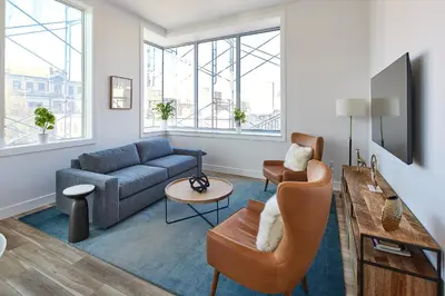 a living room with a blue couch and chairs at Prime Hoboken Lofts in Hoboken
