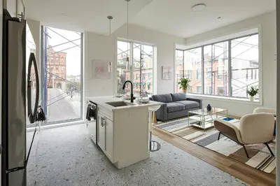 a kitchen and a living room with a couch at Prime Hoboken Lofts in Hoboken