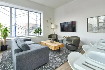 a living room with a couch and two chairs at Prime Hoboken Lofts in Hoboken