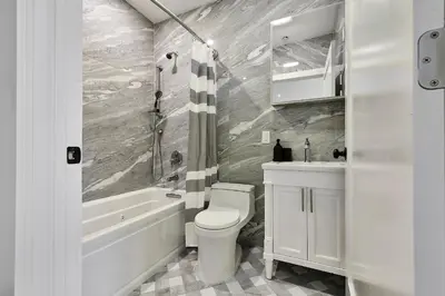 a bathroom with a toilet and a tub and a sink at Prime Hoboken Lofts in Hoboken