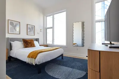 a bedroom with a bed and a flat screen tv at Prime Hoboken Lofts in Hoboken