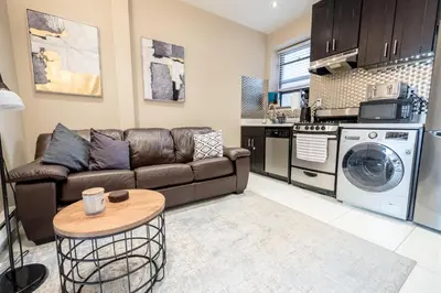 a living room with a couch and a kitchen at 2 BD Next to Central Park in New York