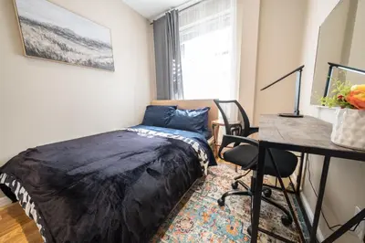 a bedroom with a bed and a desk and a window at 2 BD Next to Central Park in New York