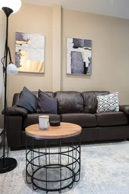 a living room with a leather couch and a coffee table at 2 BD Next to Central Park in New York