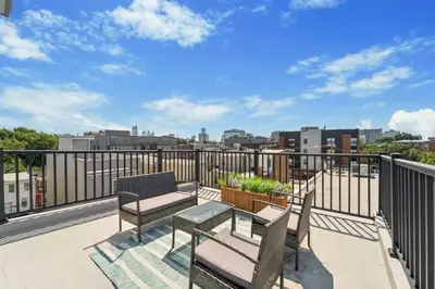 a patio with two chairs and a table on a balcony at Roof deck w city views - brand new 3bd 3ba in Philadelphia