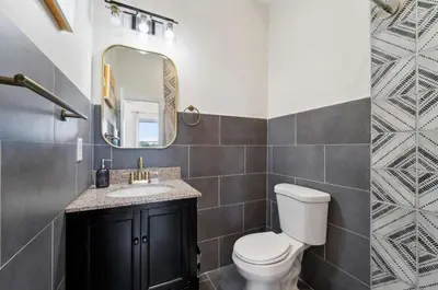 a bathroom with a toilet and a sink and a mirror at Roof deck w city views - brand new 3bd 3ba in Philadelphia