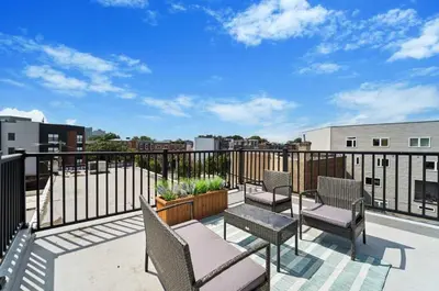 a patio with chairs and tables on a balcony at Roof deck w city views - brand new 3bd 3ba in Philadelphia