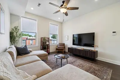 a living room with two couches and a flat screen tv at Roof deck w city views - brand new 3bd 3ba in Philadelphia