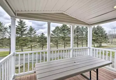 a white porch with a wooden bench on it at Clydesdale Cottage by Equestrian House in Pleasant Mount