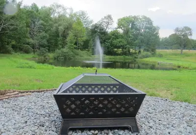 a fountain in the middle of a field with a pond at Clydesdale Cottage by Equestrian House in Pleasant Mount