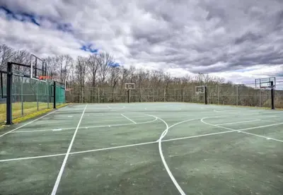 a tennis court with a basketball hoop on it at Clydesdale Cottage by Equestrian House in Pleasant Mount