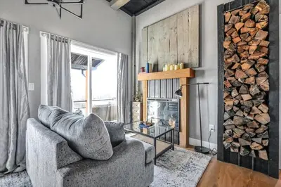 a living room with a chair and a fireplace at Paceful & Stylish Rural Retreat in Pine Grove