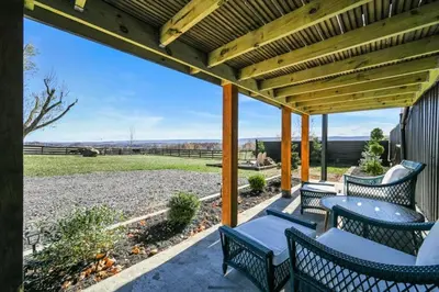 a patio with chairs and tables and a wooden pergola at Paceful & Stylish Rural Retreat in Pine Grove
