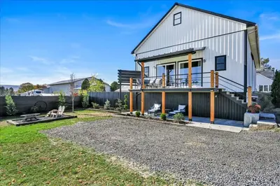 a large white house with a porch and a yard at Paceful & Stylish Rural Retreat in Pine Grove