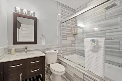 a bathroom with a toilet and a shower and a sink at Upscale NoLibs XL Studio - Pool & Gym in Philadelphia