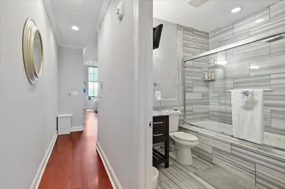 a white bathroom with a toilet and a tub at Upscale NoLibs XL Studio - Pool & Gym in Philadelphia