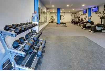 a gym with rows of treadmills and machines at Upscale NoLibs XL Studio - Pool & Gym in Philadelphia