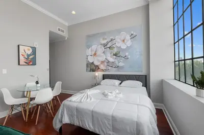 a white bedroom with a bed and a table at Modern NoLibs Studio - Pool & Gym in Philadelphia