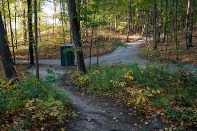 a dirt road in the woods with a sign on it at Heavens Landing at Moon Valley Campground in Vernon Township