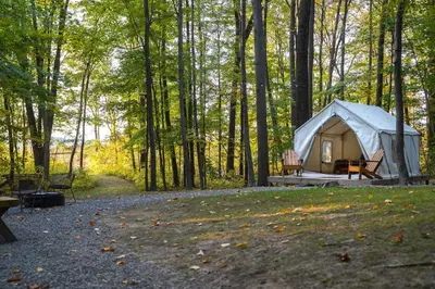 a white tent in the middle of a forest at Heavens Landing at Moon Valley Campground in Vernon Township